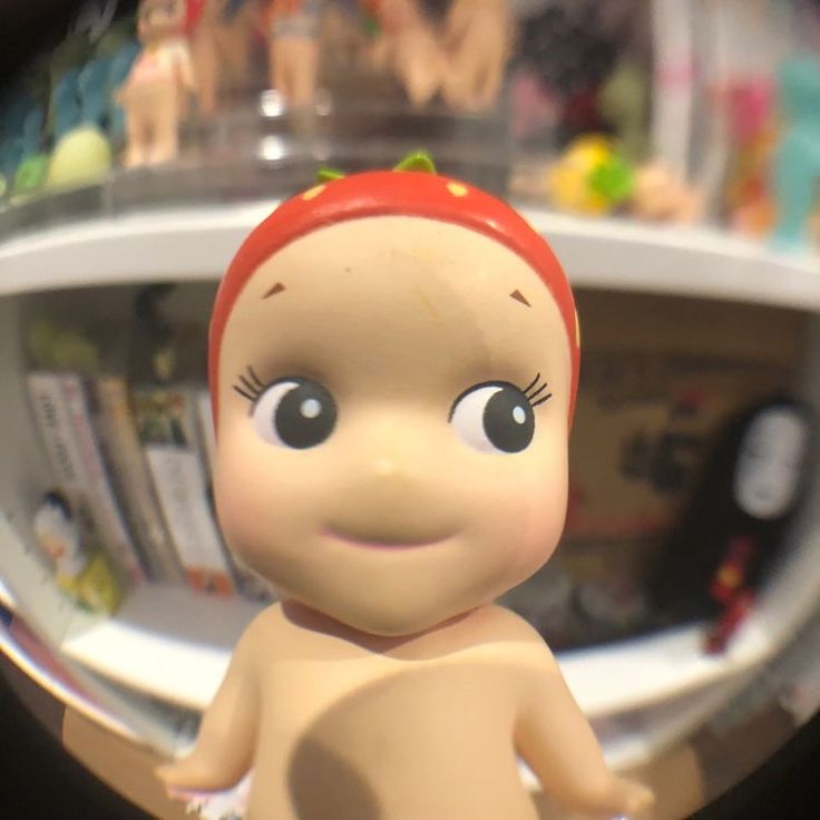 a close up of a toy doll in front of a mirror