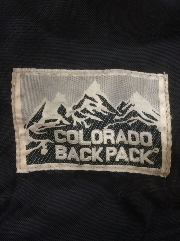 the back of a black jacket with a white and gray label on it that says colorado backpack