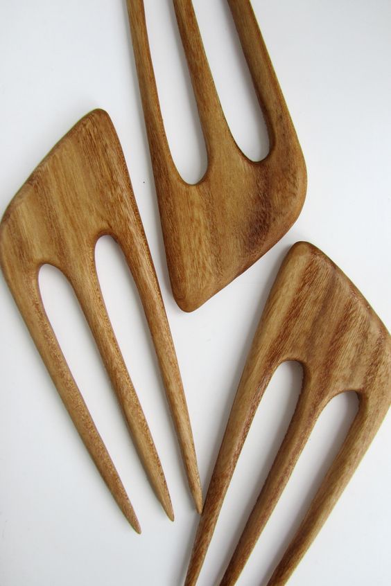 three wooden utensils sitting next to each other