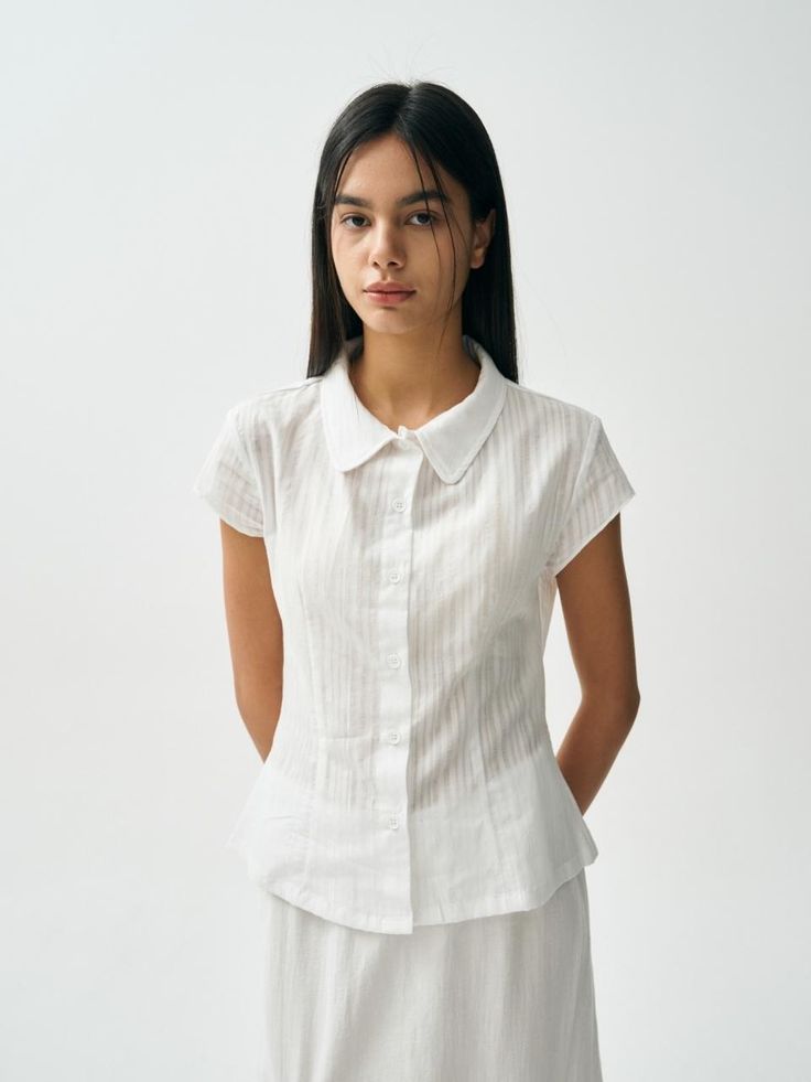 This product features the Scent Shirt, a sophisticated and versatile top perfect for both casual and formal settings. The shirt offers a tailored fit with elegant vertical stripes, adding a touch of class to any outfit. It combines comfort with a refined design, making it a valuable addition to any wardrobe. - This Scent Shirt is crafted from high-quality, breathable fabric, ensuring comfort throughout the day.- The shirt features a button-down front with a classic collar, providing a timeless and polished look.- It has vertical stripes that elongate the silhouette, adding a subtle yet stylish detail.- The short sleeves and tailored fit make it versatile for various occasions, easily pairing with skirts, trousers, or jeans for a chic and elegant appearance. Elegant Shirt With Vertical Stripes For Daywear, Elegant Vertical Striped Workwear Blouse, Elegant Vertical Stripes Blouse For Work, Elegant Workwear Blouse With Vertical Stripes, Elegant Tailored Cotton Tops, Elegant Blouse With Vertical Stripes For Work, Spring Office Shirt With Vertical Stripes, Vertical Stripes Shirt For Office In Spring, Vertical Striped Shirt For Office In Spring