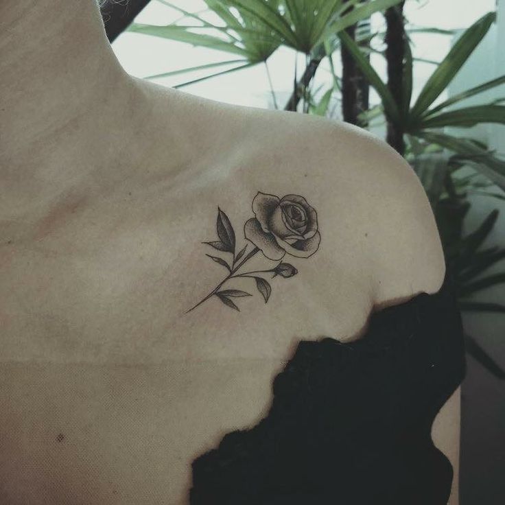 a woman's shoulder with a rose tattoo on the left side of her chest