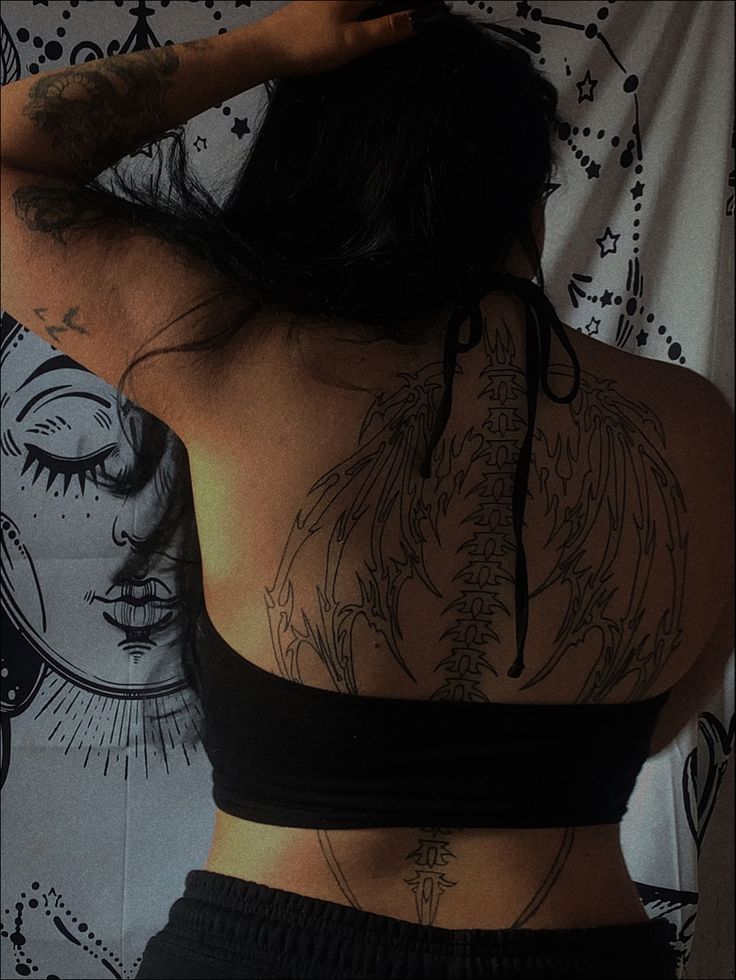 a woman with tattoos on her back