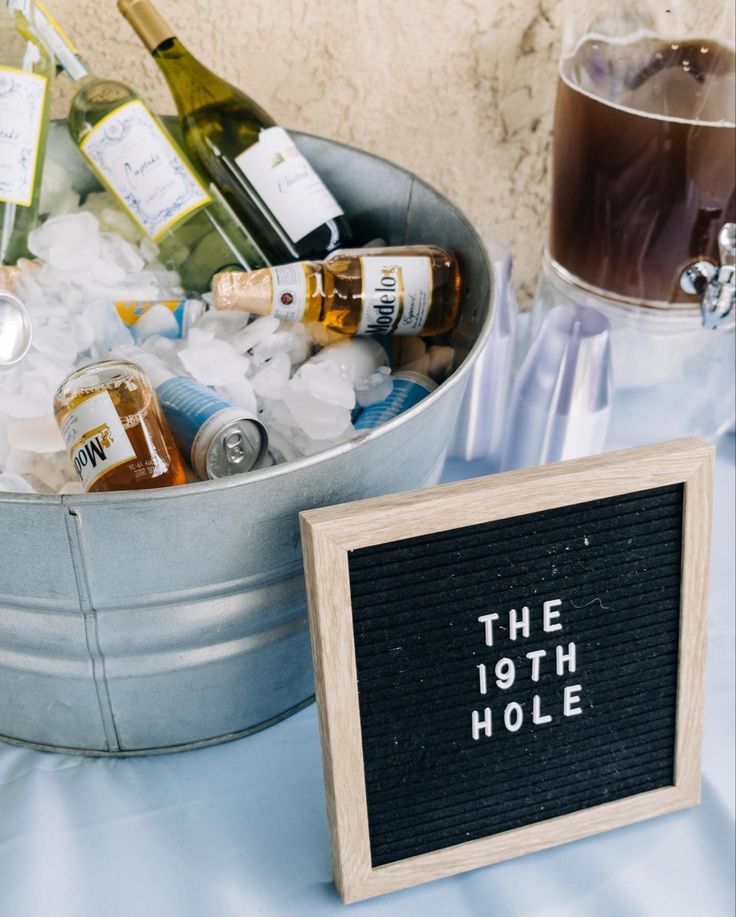 an ice bucket filled with lots of bottles next to a sign that says the 10th hole