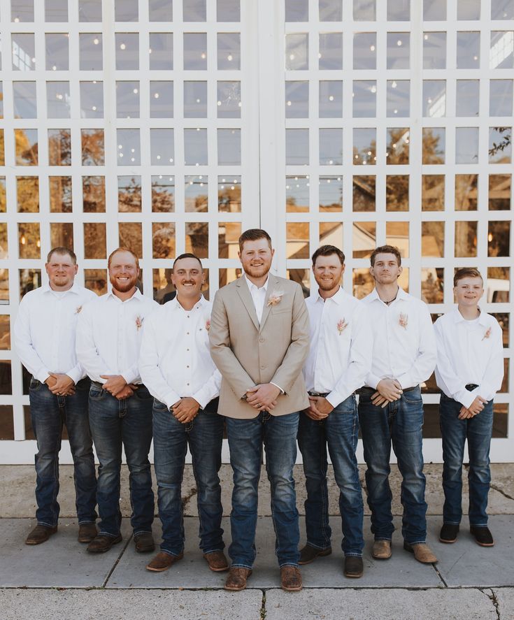 a group of men standing next to each other in front of a white building with large windows