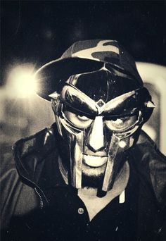 a man wearing a helmet and goggles with his face painted like an alien in black and white