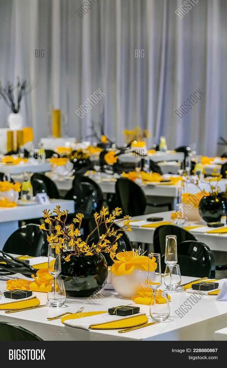 the tables are set with yellow and black place settings