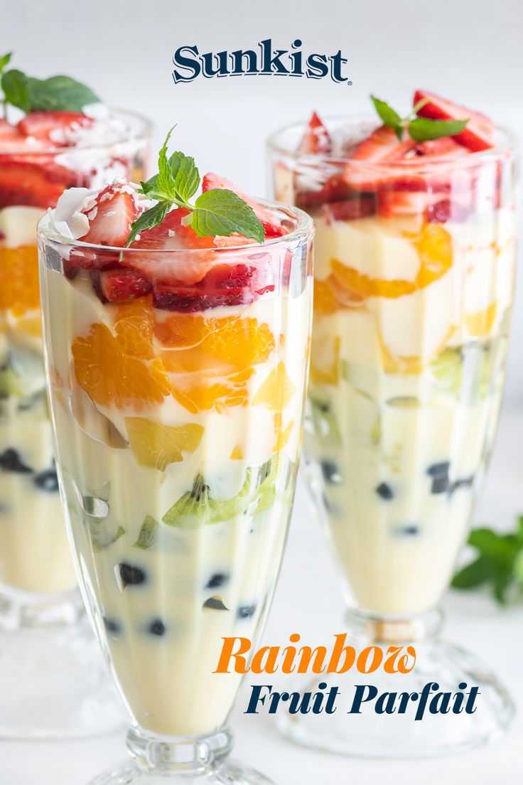 two glasses filled with fruit salad on top of a table