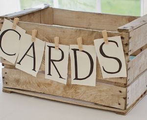 a wooden crate with clothes hanging from it's sides and the words cards on them