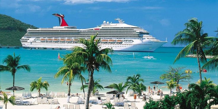 a cruise ship docked at the beach with palm trees and lounge chairs in front of it