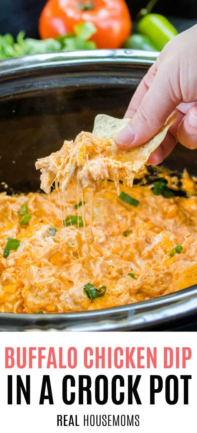 a hand dipping a tortilla chip into a crock pot filled with chicken