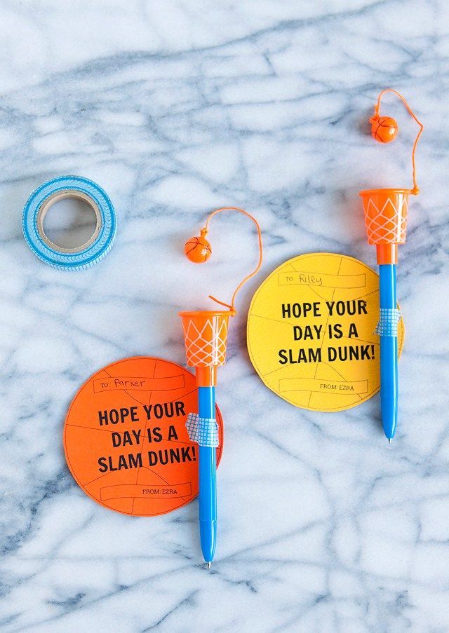 two orange and blue items sitting on top of a marble counter next to a tape dispenser