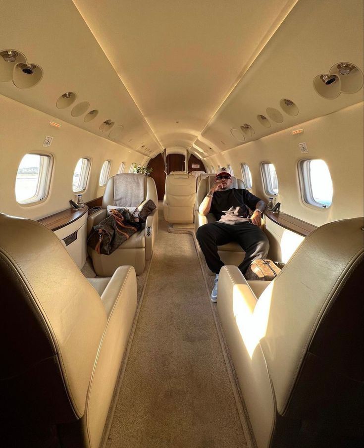 two men sitting in the aisle of an airplane with their feet propped up on seats