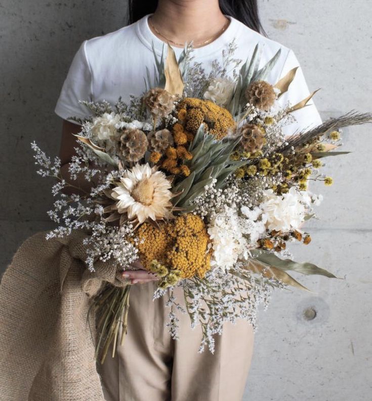 a woman holding a bouquet of flowers in her hands