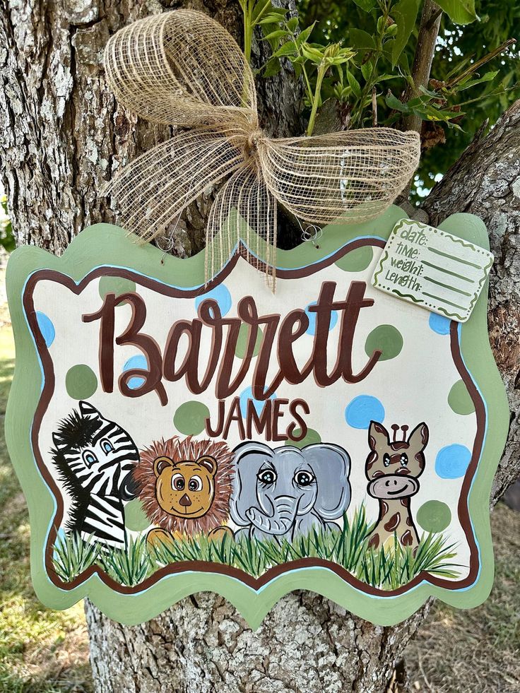 a sign that says barbett james with pictures of animals on it hanging from a tree