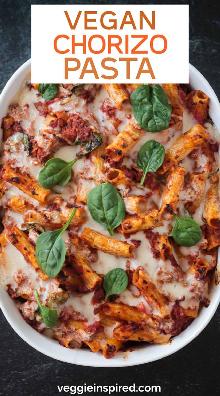 vegan chorizzo pasta in a white bowl with basil leaves on the side