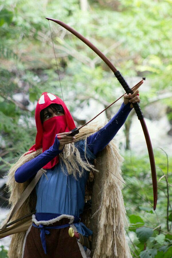 a man dressed in costume holding a bow and arrow