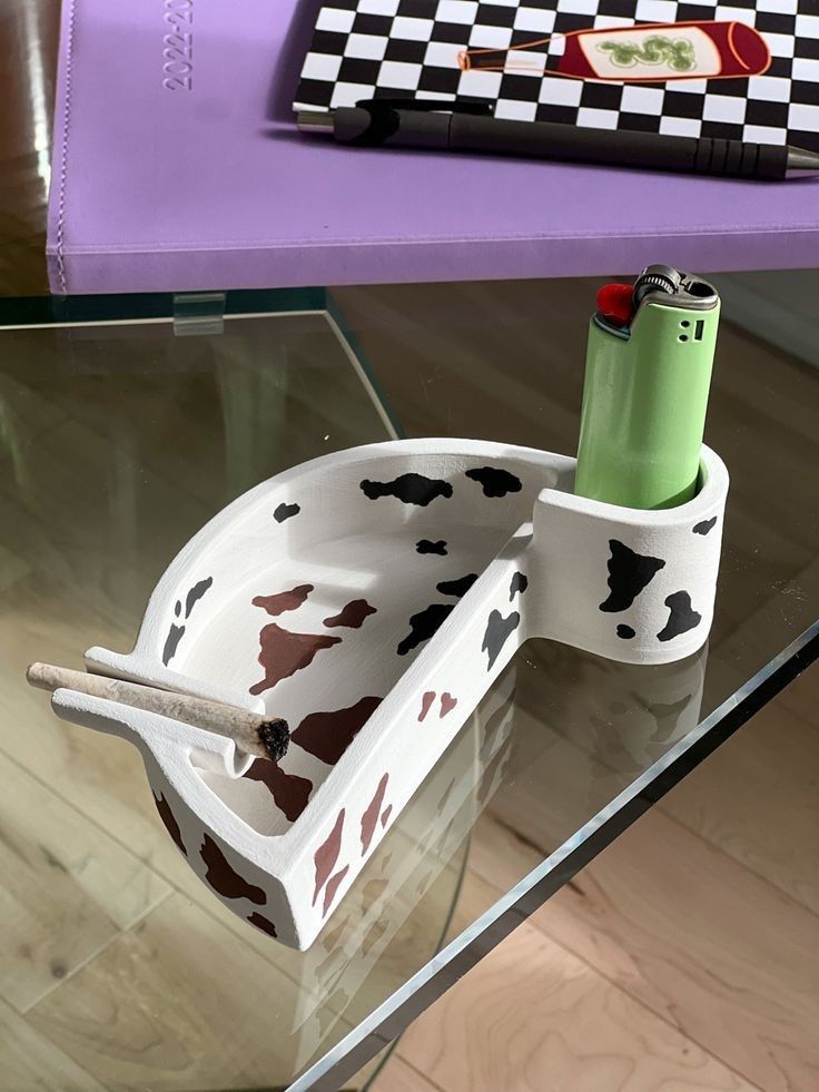 a glass table topped with a container and pen holder