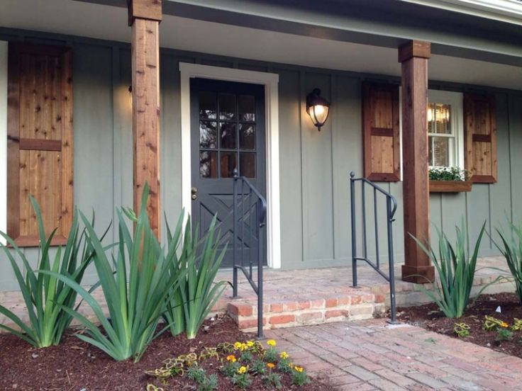 a house with wooden shutters and brick walkway leading to the front door is shown