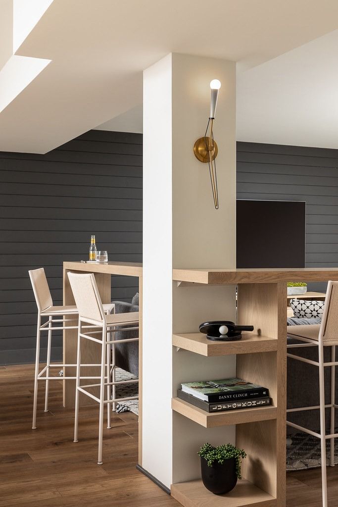 an open kitchen and dining room area with wood flooring, white walls and wooden floors