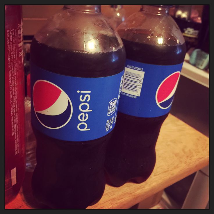 two pepsi soda bottles sitting on top of a counter