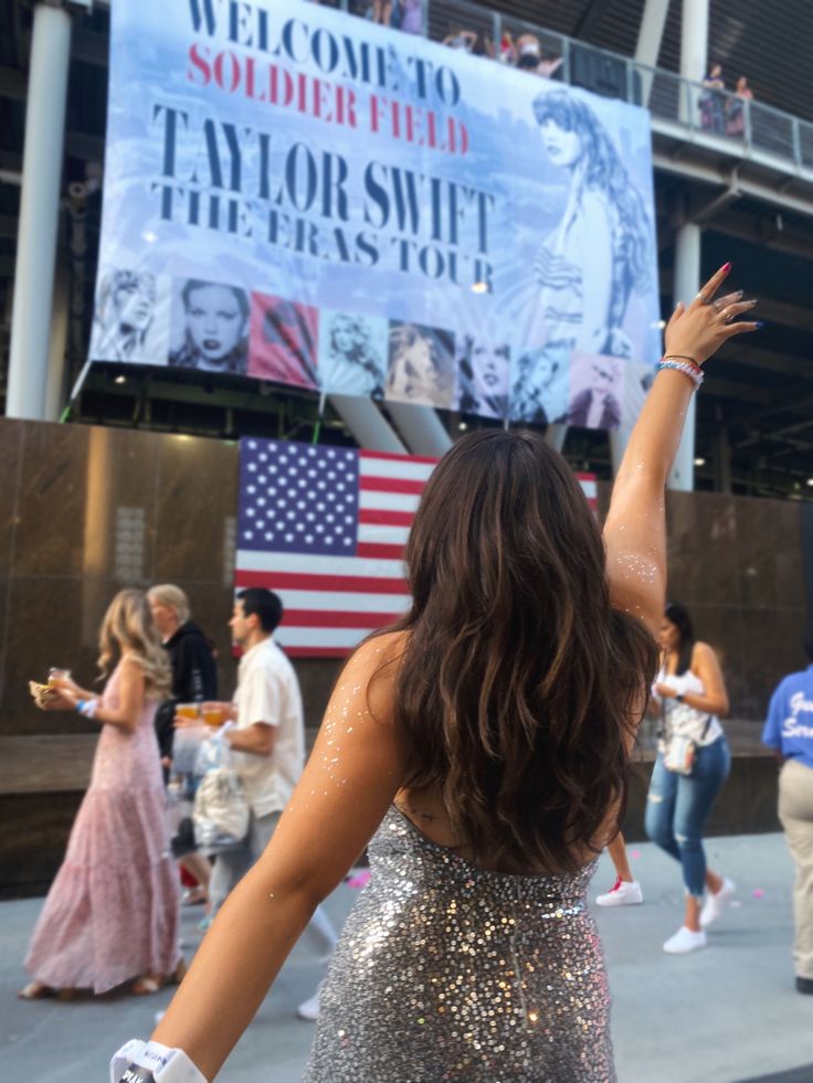 a woman in a sequined dress is holding her arms up with both hands