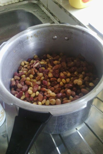 a pot filled with beans sitting on top of a stove