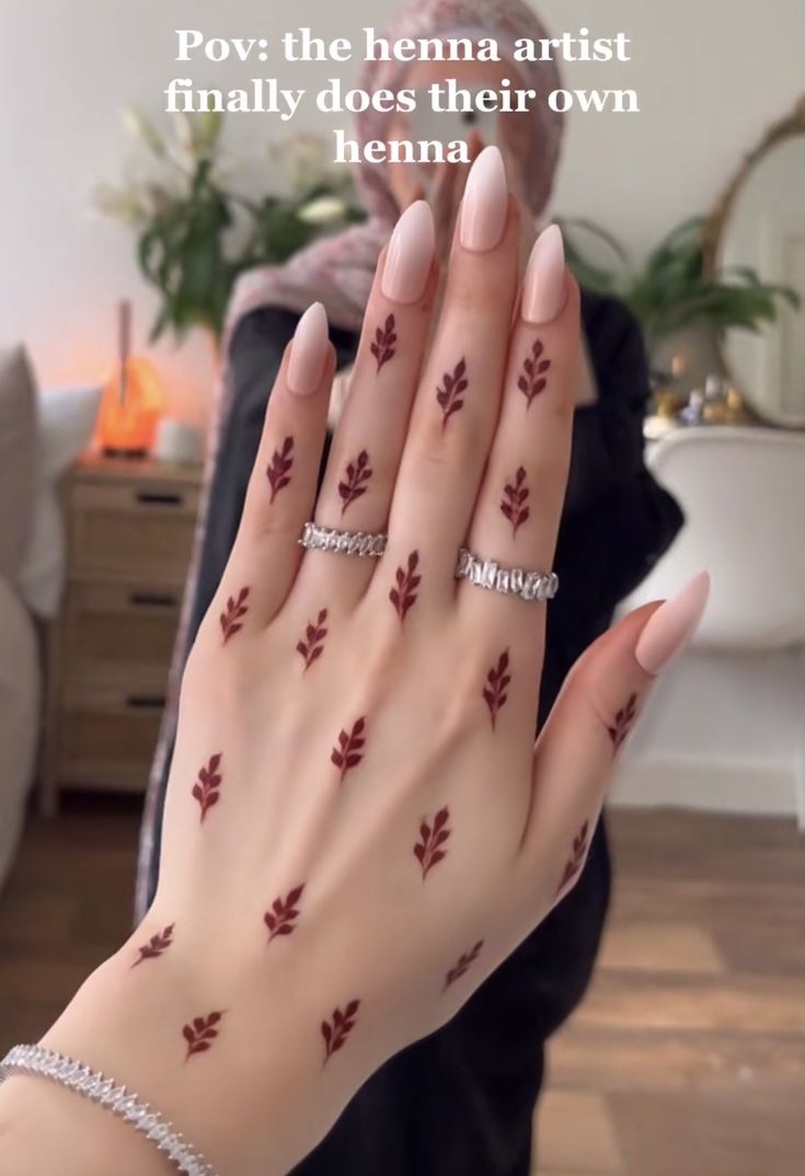 a woman's hand with red leaves painted on it and the words pov the hema artist finally does their own henna