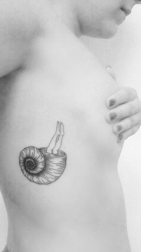 a woman's chest with a snail tattoo on it