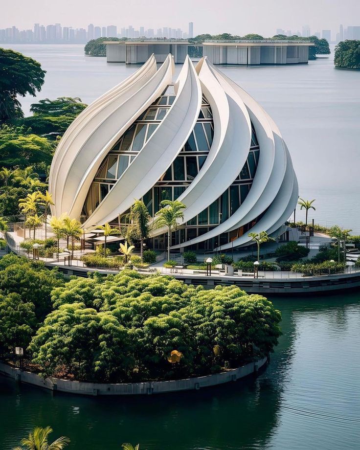 an unusual building sits on the edge of a body of water with trees around it