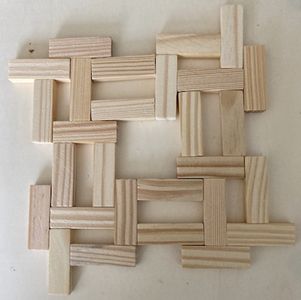 wooden squares arranged in the shape of a rectangle on a white surface with one block missing