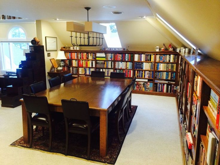 a dining room table with chairs and bookshelves