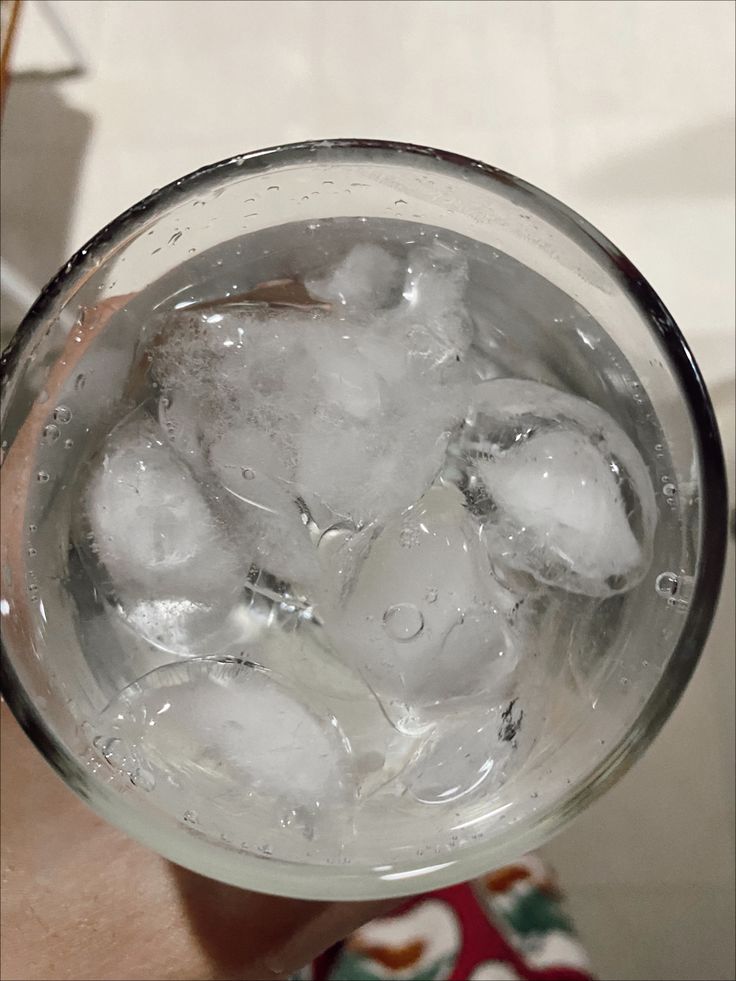 a glass filled with ice sitting on top of a table