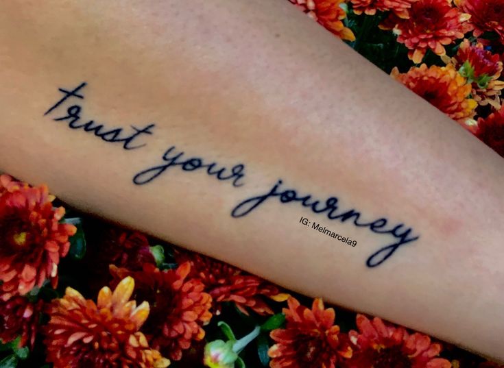 a woman's arm with the words trust your journey written on it in cursive font