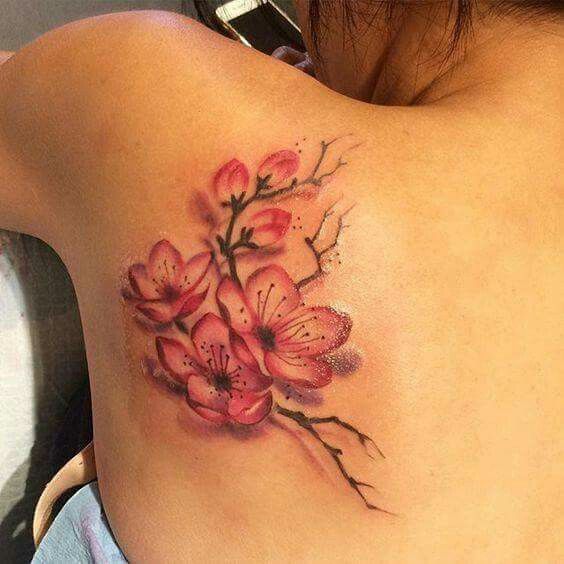 a woman's back tattoo with pink flowers on it