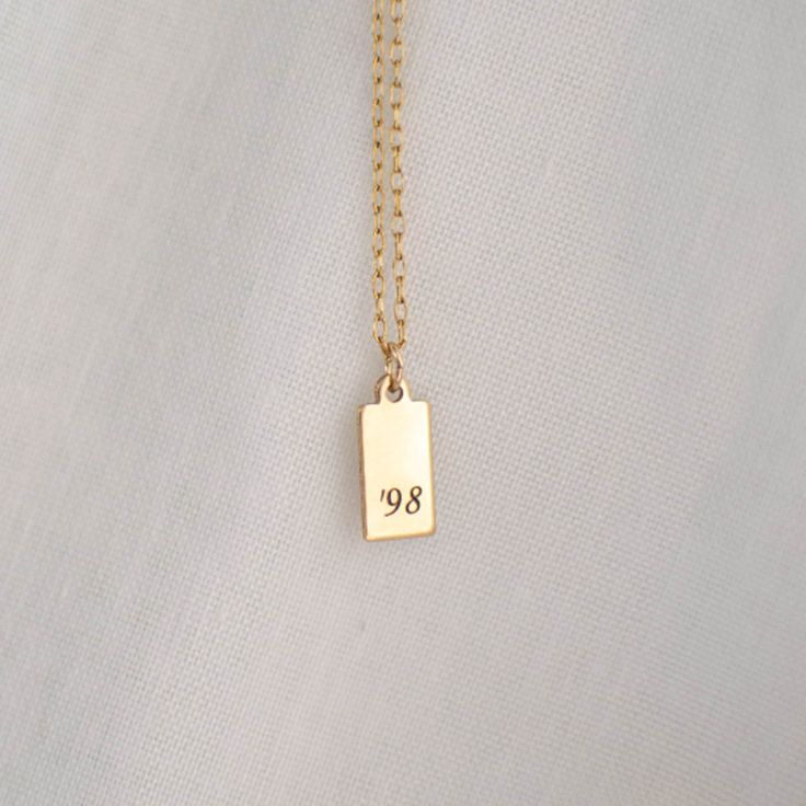 "Personalized Gold Rectangle Pendant Necklace from our Memoirs Made Collection. Personalize a short word or up to three initials on the lovely 14k gold filled tag necklace Free Engraving for a limited time! NECKLACE DETAILS ⚬ 14k gold-filled rectangle and chain. ⚬ Chain in your choice of 16\", 18\", or 20\" length ⚬ Rectangle measures 13.5mm x 6mm (.53\" x .23\"). ⚬ Spring ring clasp closure. ⚬ Personalized engraving of 1-3 characters (including spaces); ⚬ Choice of 3 fonts for the engraving. ⚬ Classic Name Necklace For Birthday, Gold Nameplate Charm Necklace For Birthday, Everyday Gold Nameplate Charm Necklaces, Everyday Gold Nameplate Charm Necklace, Classic Yellow Gold Name Necklace For Birthday Gift, Classic Tarnish Resistant Name Necklace For Anniversary, Classic Tarnish-resistant Name Necklace For Anniversary, Everyday Gold Nameplate Necklace, Gold Sterling Silver Initial Necklace For Birthday