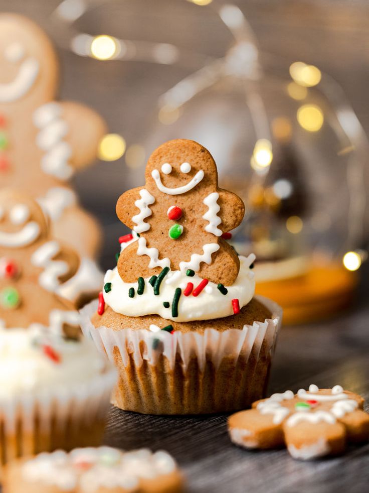 gingerbread cupcakes decorated with icing and sprinkles on a table