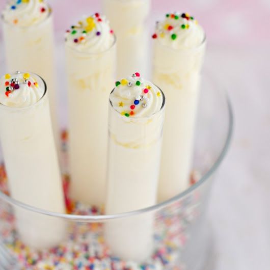 a glass bowl filled with cake batter and sprinkles on top of a table