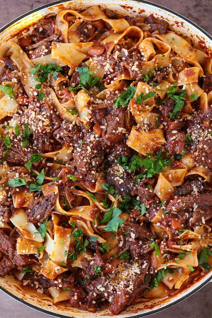 a pan filled with pasta, meat and parsley