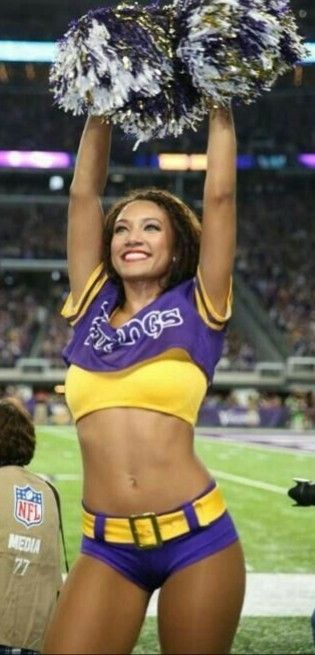 a cheerleader is holding up her pom - poms at a football game