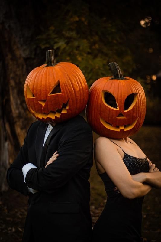 a man and woman dressed up as jack - o'- lanterns