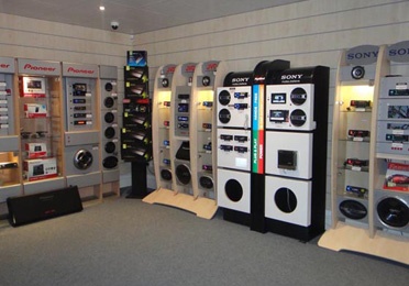 a room filled with different types of machines and speakers on display in front of the wall