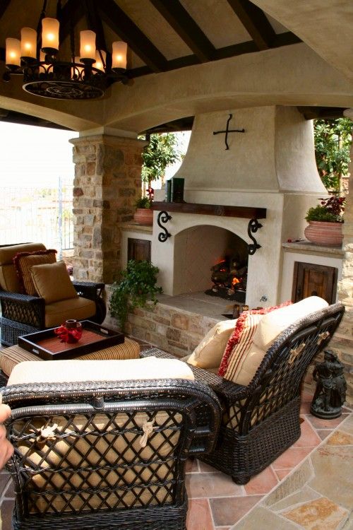 an outdoor living area with furniture and fireplace