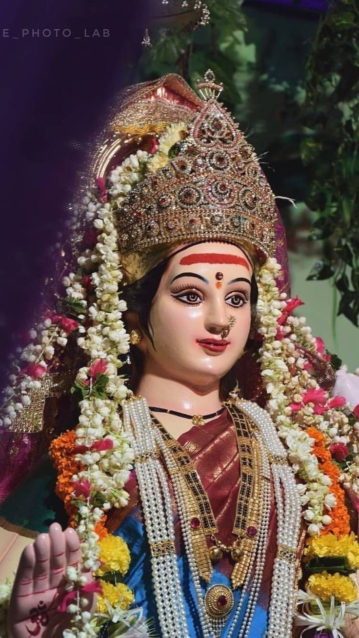 a statue of the hindu god with flowers in his hair and garlands around his neck