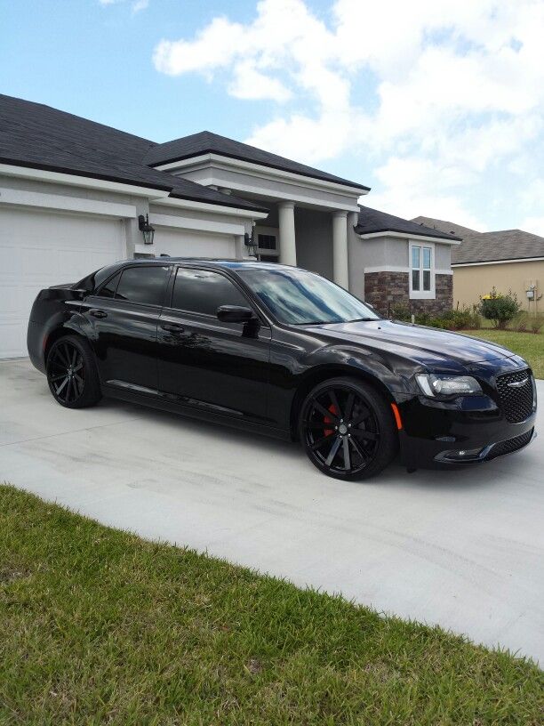 a black sports car parked in front of a house