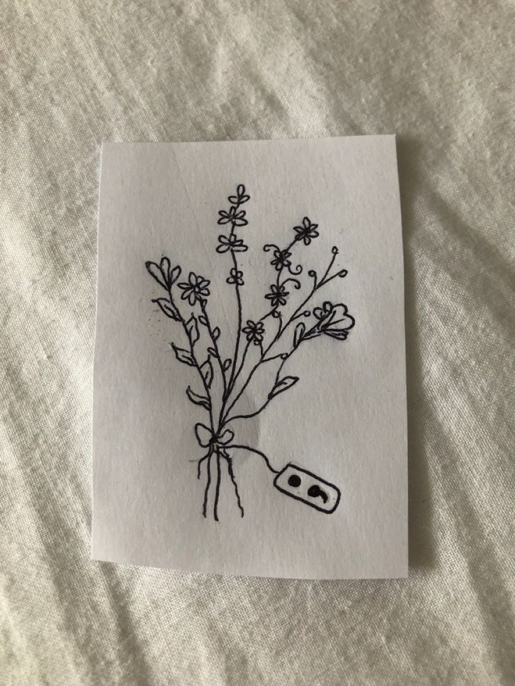 a piece of paper with a drawing of flowers on it and an object in the middle