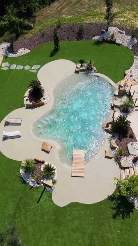 an aerial view of a swimming pool surrounded by grass