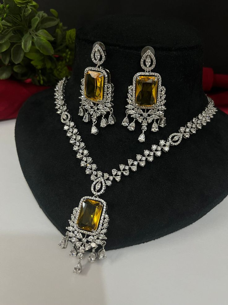 Gorgeous fine quality imitation jewellery  CZ Yellow with diamonds studded necklace with white gold rhodium plating and matching Earrings Item contains: Necklace and earrings AAA quality cubic zirconia used. Highest quality and craftsmanship Necklace Fitting is adjustable Earrings Closure: Pushback Necklace Closure: chain with Hook Details-  -Handmade item -Delivery from a small business in India -Materials: white rhodium, stones, cz, zircon, American diamond -Jewellery type: Earrings, Necklace Festive Dazzling Cubic Zirconia Jewelry, Festive Cubic Zirconia Bridal Necklace For Formal Occasions, Festive Formal Bridal Necklace With Cubic Zirconia, Gold Jewelry Sets With Diamond Cut American Diamond, Gold American Diamond Jewelry Sets With Diamond Cut, Festive Yellow Hallmarked Jewelry, Dazzling Jewelry With Diamond Accents For Festivals, Dazzling Festive Jewelry With Diamond Accents, Dazzling Jewelry With Diamond Accents For Festive Season