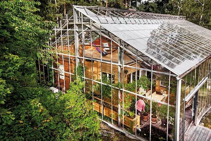 a house that is surrounded by trees and has a roof made out of metal bars