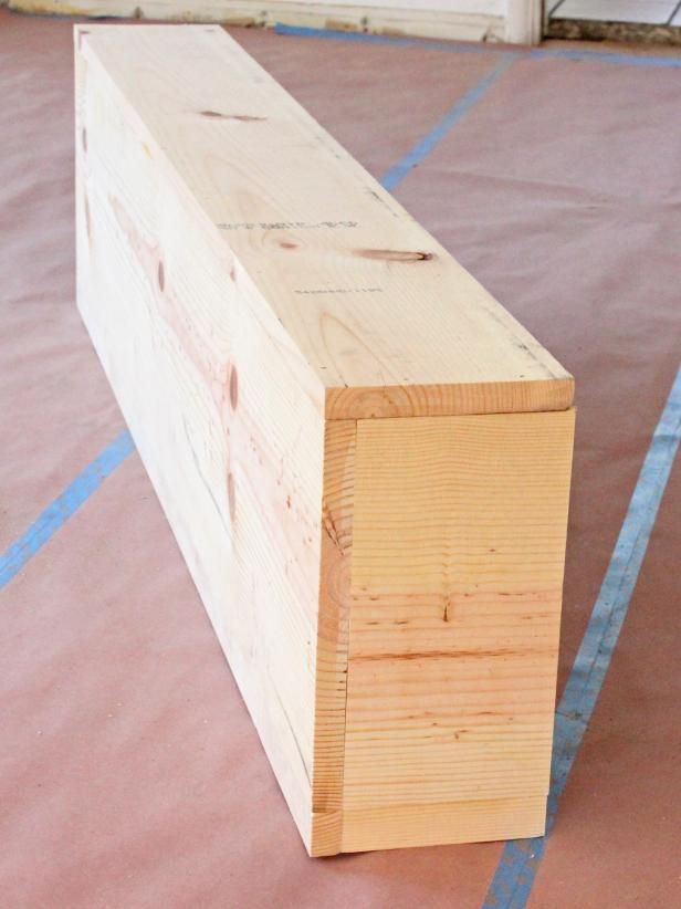 a piece of wood sitting on top of a floor next to a blue line in the ground