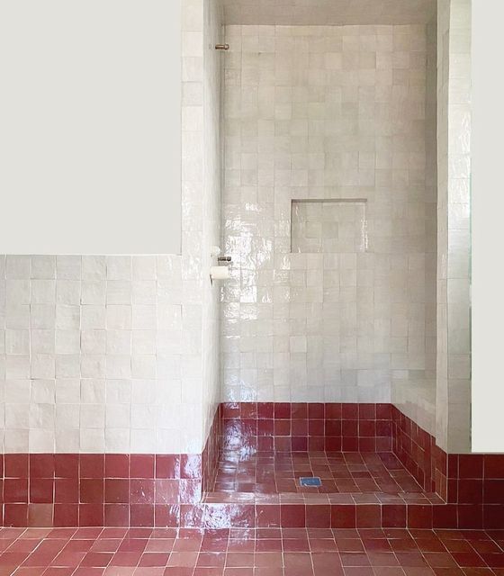 a bathroom with red tile and white walls